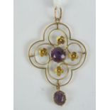 A delightful Edwardian pendant having floral scroll work pattern with central round cut amethyst