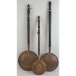 Three assorted copper warming pans, each with turned handle.