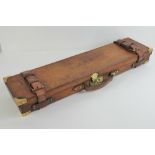 A fine leather 410 (farmers son) gun case having brass corner bracing and lock,