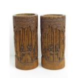 A pair of carved bamboo decorative cylindrical pots each standing 24cm high, 11cm dia.