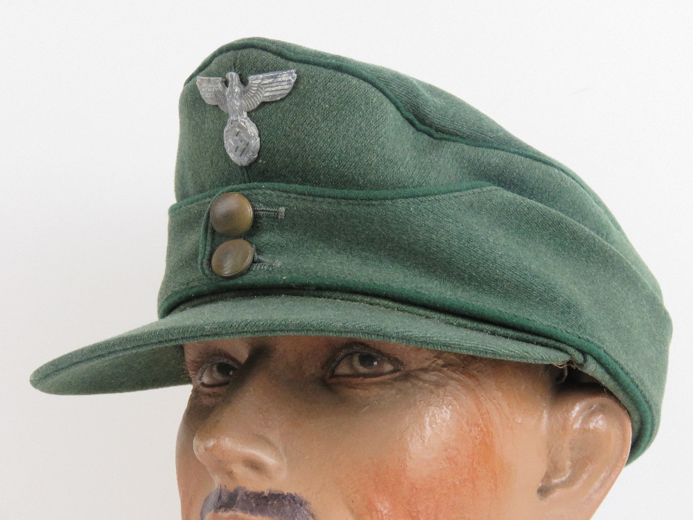 A WWII German Forestry Officers M43 style peaked cap having green piping and eagle over swastika