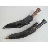 Two Kukris in leather covered wooden sheaths complete with two companion knives in each.