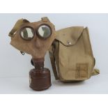 A WWII Japanese civilian gas mask with filter and carry bag with label.