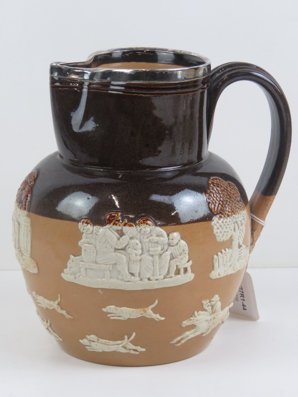 A Doulton harvest jug with silver rim hallmarked Sheffield 1903, 19cm high.