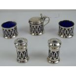 A delightful geometric HM silver five piece cruet set having Bristol blue glass liners,