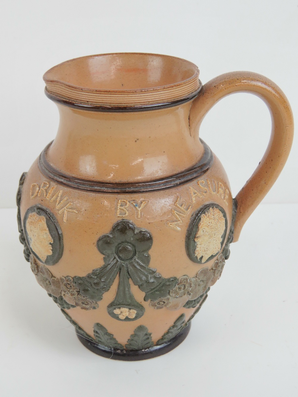 A Doulton Lambeth applied jug 'Bread at Pleasure, Drink by Measure', 12cm high. - Image 2 of 3