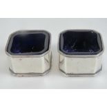 A pair of octagonal HM silver salts having Bristol blue glass liners, hallmarked Birmingham 1947,