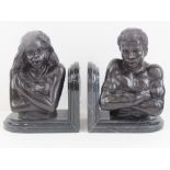 A pair of polished marble and bronzed spelter bookends in the form of a male and female,