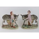 Staffordshire flatbacks; donkeys with basket and boy and girl, an opposing pair, 19cm high.