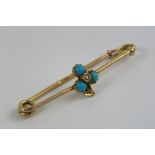 A Victorian bar brooch having trefoil leaf set with three turquoise cabachons and central diamond,