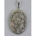 A 925 silver locket of oval form with floral engraving upon, 5.5cm including bale.