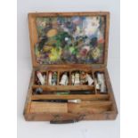 A vintage Continental paint box containing a well used thumb palette,