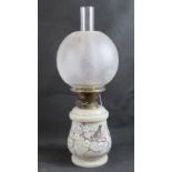 A 19th century oil lamp having opaque glass base with branch and foliage decoration,