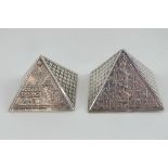 Two White metal Egyptian pyramids decorated with sphinx and hieroglyphics upon,