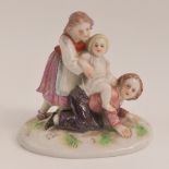 A delightful hand painted figurine of children at play bearing backstamp 'R' under, 7.5cm high.