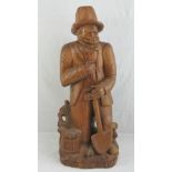 A solid carved wooden figurine, elderly gentleman with shovel in hand, 84cm high.