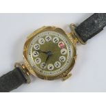 A 9ct gold ladies cocktail watch having blued steel hands with red and black Arabic numerals,
