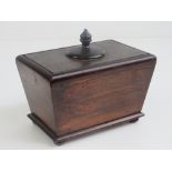 A 19th century rosewood sarcophagus tea caddy lid lifting to reveal silvered compartment within,