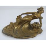 A gilded spelter Art Nouveau inkwell in the form of a recumbent female, 20cm wide,