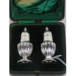 A pair of miniature HM silver pepperettes having gadrooned bodies and standing 6.