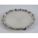 A HM silver salver having pie crust edge and raised over four scroll feet,