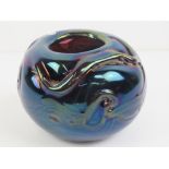 An iridescent spherical relief glass bowl marked J Ditchfield 1980 under, 11cm diameter.