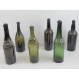 Six antique glass bottles including two with integral seals.