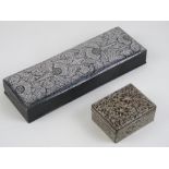 A heavy silvered pen box, 23cm in length. Together with a once silver plated floral relief box.