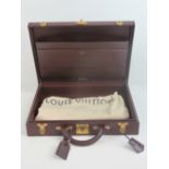 A burgundy leather covered Louis Vuitton briefcase bearing LV to the locks,