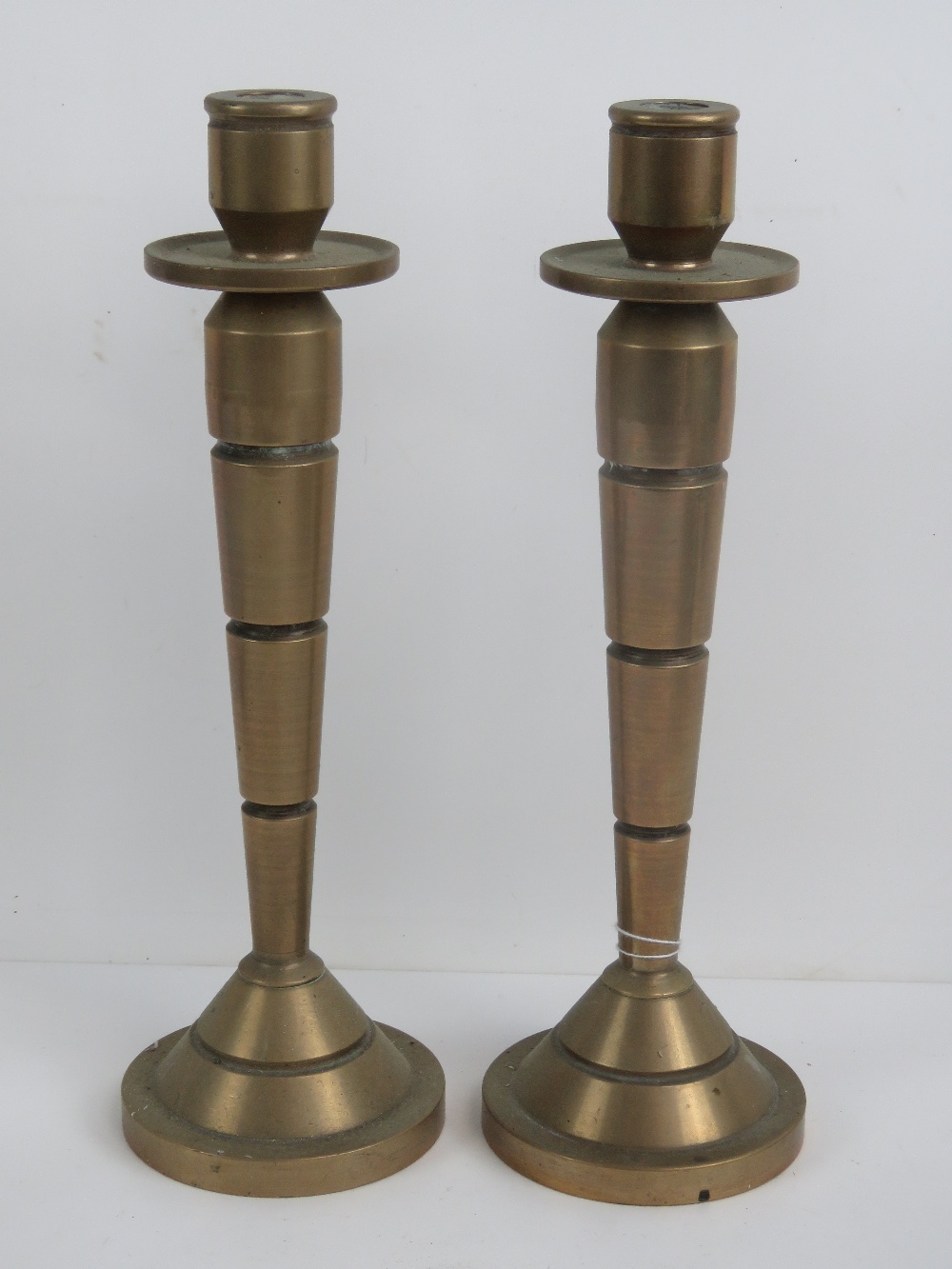 A fine pair of heavy Art Deco graduating and banded solid brass candlesticks,
