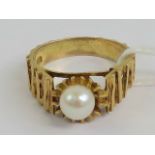 A 9ct gold ring set with faux pearl having bark effect shoulders, stamped 9ct, size N, 4.5g.