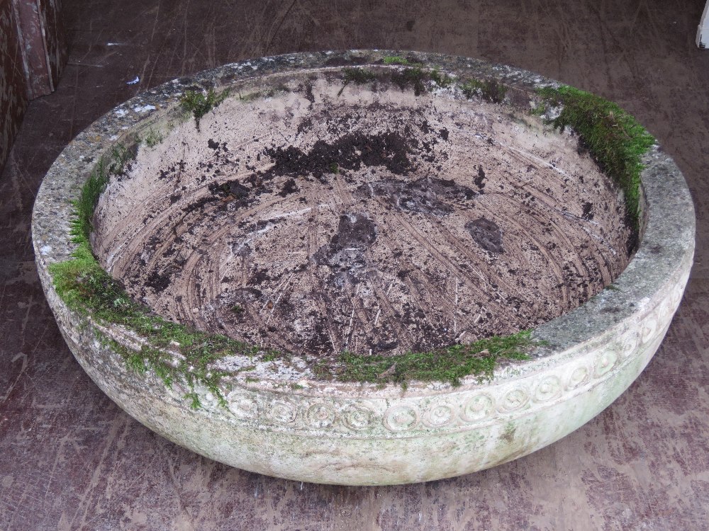 A large circular garden planter / birdbath in composite stone and having early English style