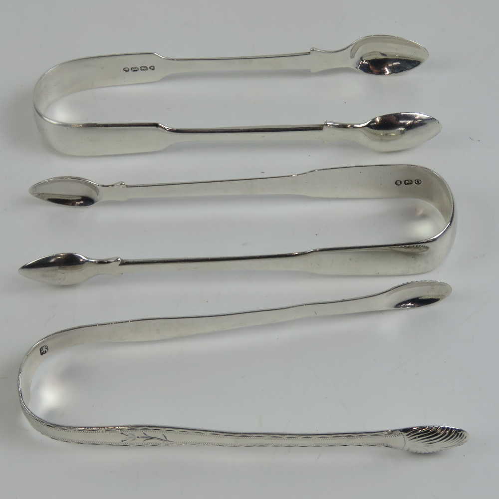 Three HM silver pairs of sugar tongs; one pair with floral engraving, lion passant, no date letter,