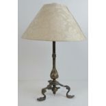 A triform table lamp base in cast brass, with shade.
