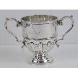 A HM silver twin handled trophy, having gadrooned body and single round foot,