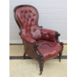 A fine Victorian gentlemans button back chair raised over shaped legs terminating in ceramic and