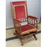 An early 20th century American rocking chair raised over castors.