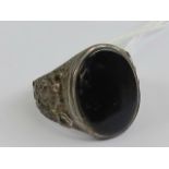 A silver and black onyx ring, the large central oval onyx approx 18 x 14mm, stamped silver, size T.