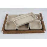 A Clarice Cliff hors d' oeuvres comprising a wooden tray having six square shaped 10cm dishes,