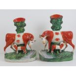 Staffordshire flatbacks; cows and calves, an opposing pair of spill vases, 28cm high, a/f.