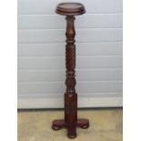 A short mahogany torchere stand raised over x-framed base, 106cm high.