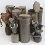 Six assorted WWII gas masks in cannisters.