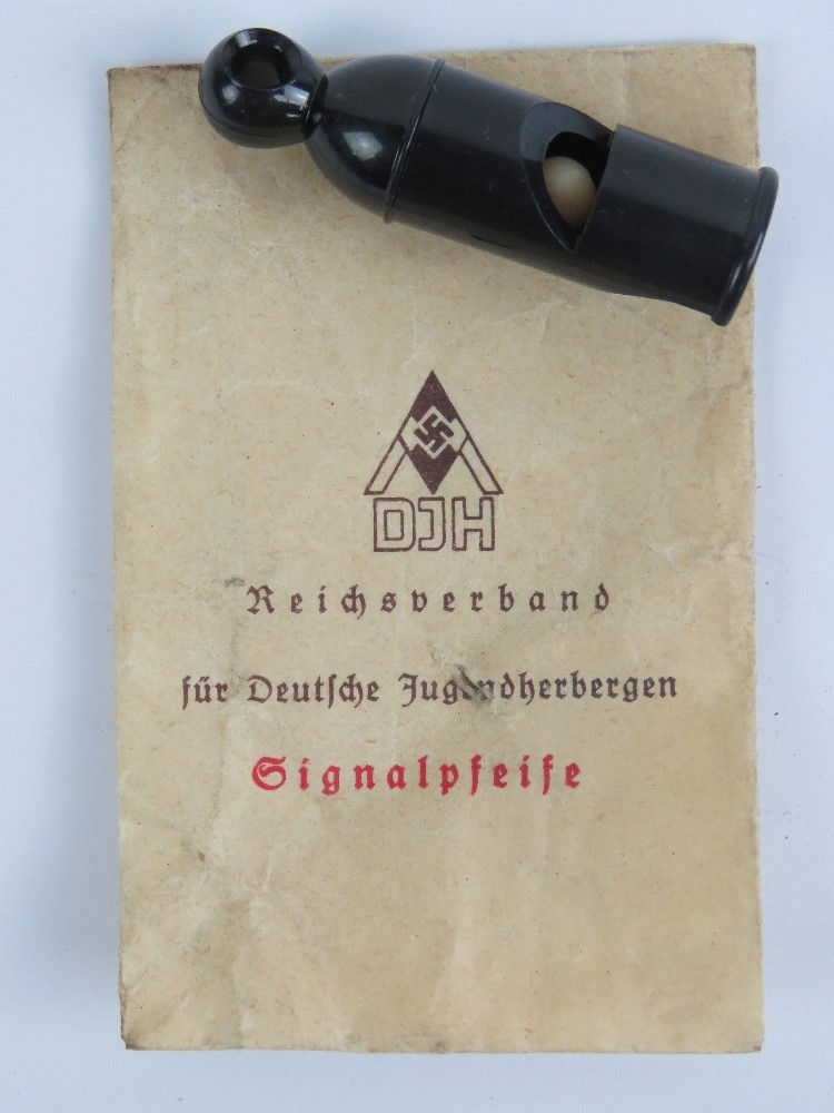 A WWII German Hitler youth whistle with original issue packet.