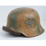 A WWII German M42 Luftwaffe helmet, with tan camo and single decal upon with liner and chin strap.