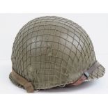 A WWII US infantry helmet with liner and netting over.