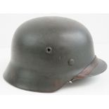 A WWII German army M40 helmet having single decal upon, chin strap and partial liner,