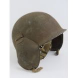 A US M3 Flak helmet with hinged ear covers and partial lining.