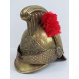 A French 19th century fireman's helmet in brass having red plume upon.