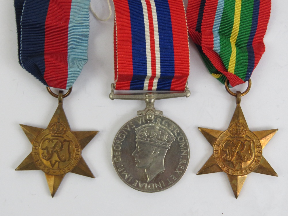 A trio of WWII medals with ribbons being War medal, Pacific Star and 1939-1945 Star.