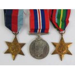 A trio of WWII medals with ribbons being War medal, Pacific Star and 1939-1945 Star.